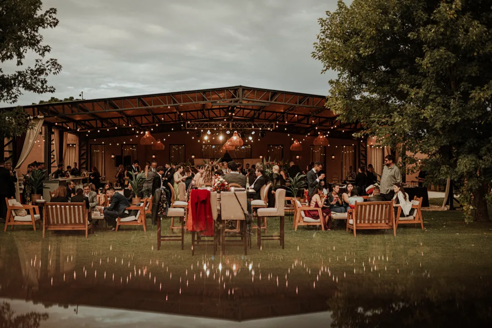 Recepción de casamiento en la galería iluminada, vista desde el parque