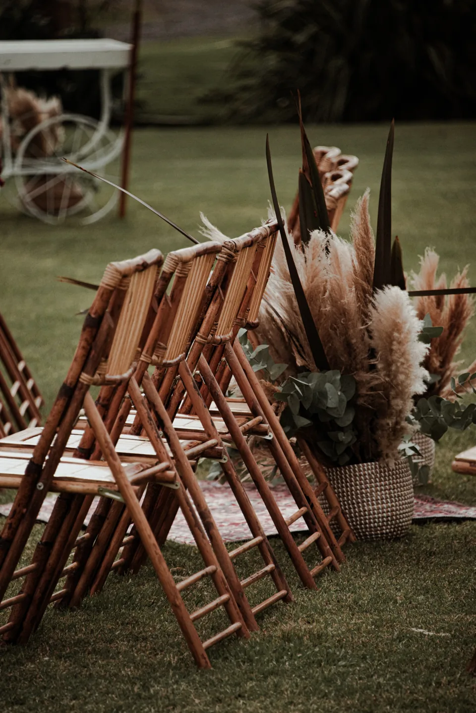 Sillas de madera y arreglos florales junto al pasillo de la ceremonia