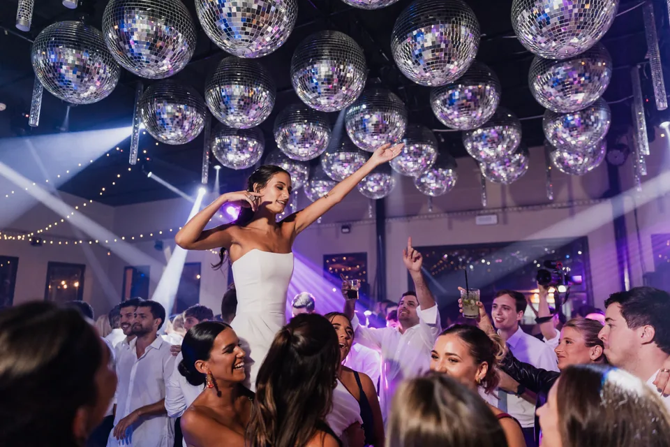 Novios e invitados celebran bajo el techo de esferas espejadas