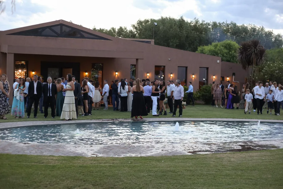 Invitados frente al salón y a la fuente durante un evento de día