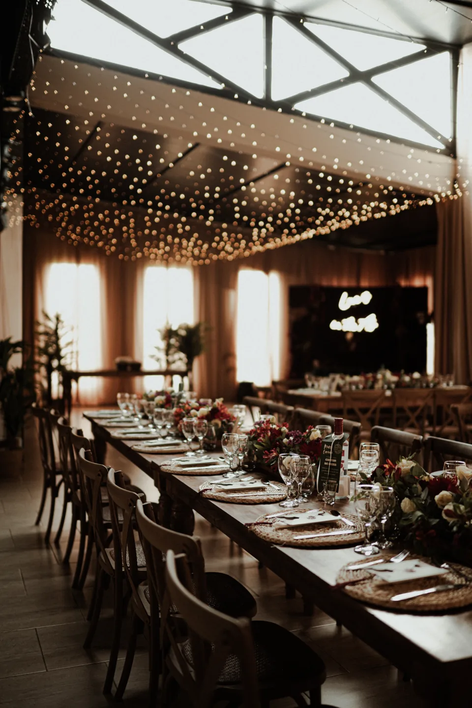 Mesa larga de casamiento bajo las guirnaldas del salón