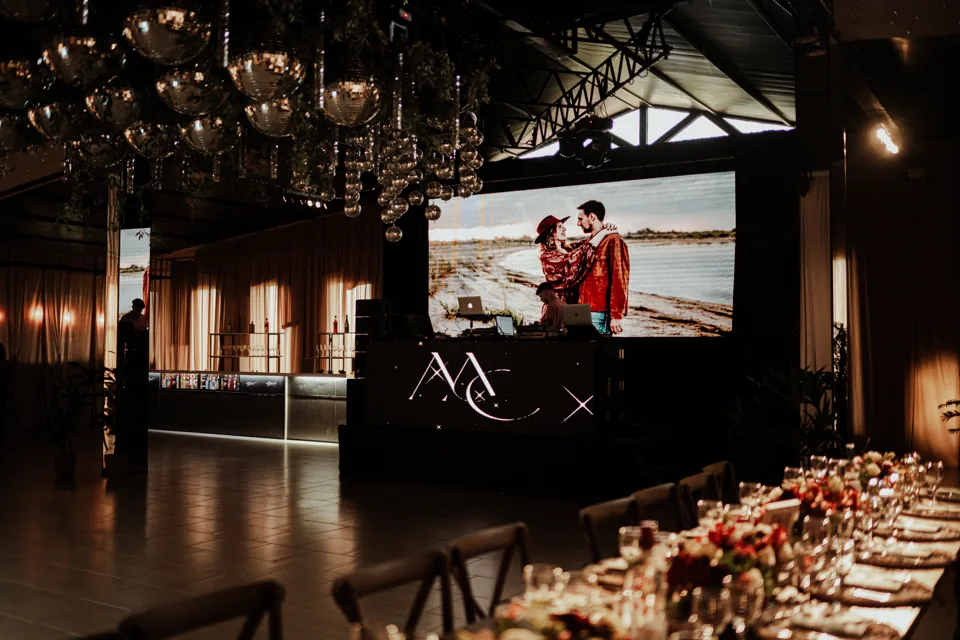 Pantalla LED con imágenes de una pareja junto a la mesa del salón